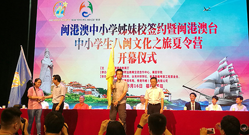 香港学生代表从福建省港澳办副主任林学锋(左二)接过「2017闽港澳中小学生夏令营」营旗