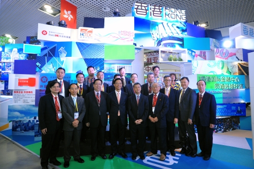 商務及經濟發展局副局長梁敬國（左四）及駐粵辦主任鄧家禧（左二）與香港商界人士在投資推廣署和香港貿發局合辦的香港館前合影。