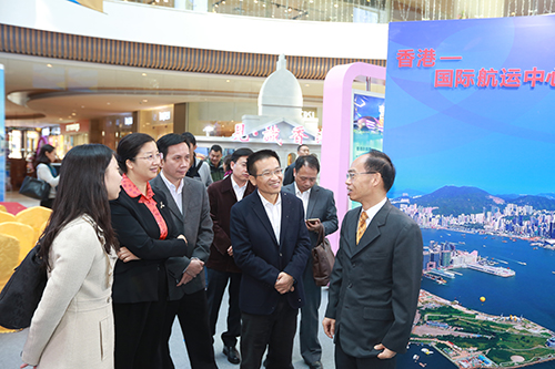 鄧家禧（右一）向龔國平（右二）及朱蔚蔚（左二）介紹「見‧識香港」展覽內容。