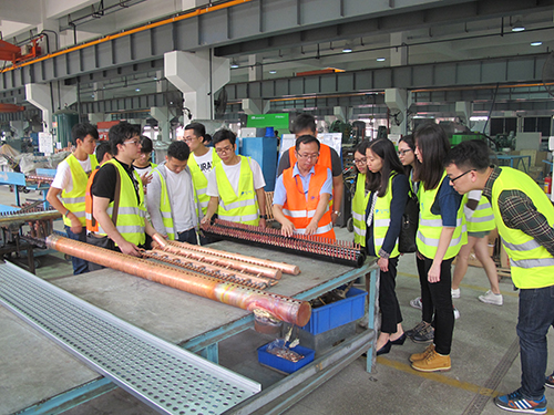 高美空调设备有限公司人员向学生介绍厂房生产设施