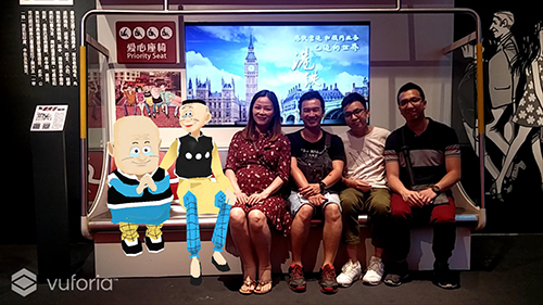 參觀香港館的市民通過虛擬實景手機程式興致勃勃地與香港著名卡通人物老夫子“合影”。