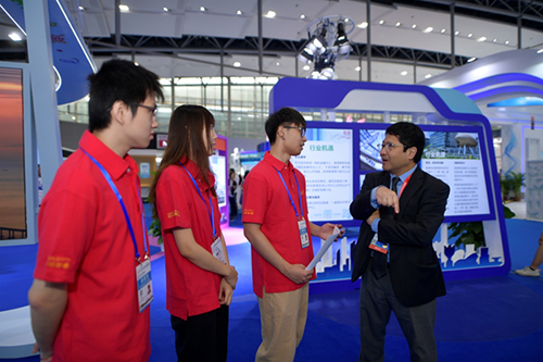 驻粤办主任陈选尧和在驻粤办实习的在粤香港学生蔡昭铭（左一）、李欣婷（左二）及林嘉浩（左三）交谈，了解他们参与协助展览的情况。