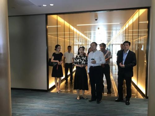 吳煒（右二）在王卓然（右一）陪同下聽取香港青年（內地）創業服務中心工作人員的介紹