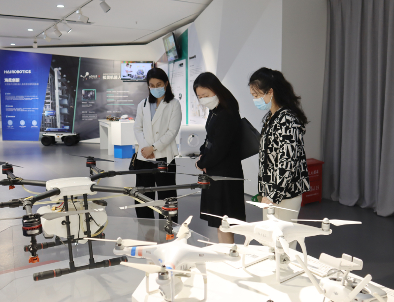 苏惠思（中）参观松山湖国际机器人产业基地，了解基地为初创型企业提供的协助