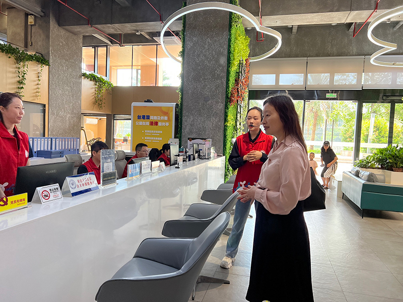 工作人員向蘇惠思（右一）介紹漁邨社區黨羣服務中心的各種服務。