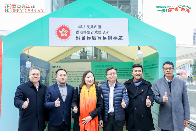 蘇蘇惠思（左三）與東莞市委常委、副市長刑文聚（右三）、東莞市外商投資企業協會會長連漢森（右二）在駐粵辦工作職能介紹展示架前合影