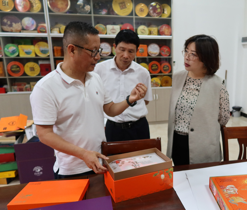 企業負責人吳東燦董事長（左一）向蘇紫賢（右一）及茂名市委台港澳辦副主任蔡進雄（左二）介紹各種食品包裝產品