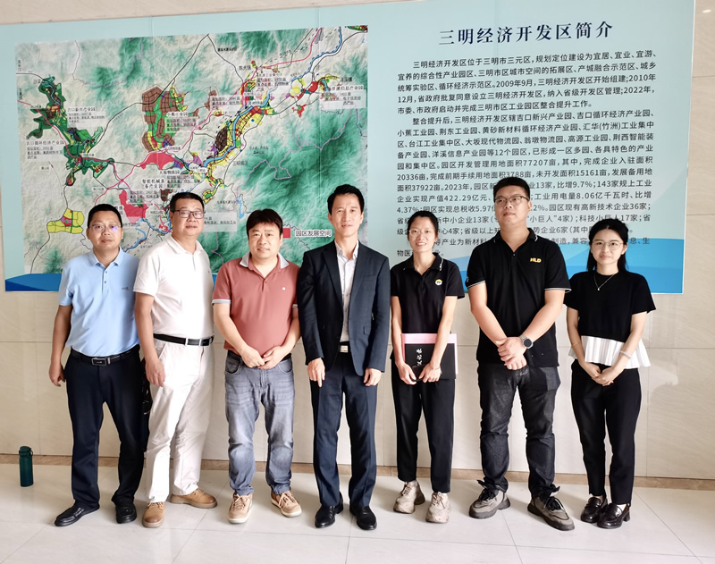 郑震生(中)一行人与三明市商务局副局长赖勤(左3)及该公司生产部经理廖巧阳（女）(右3)合照