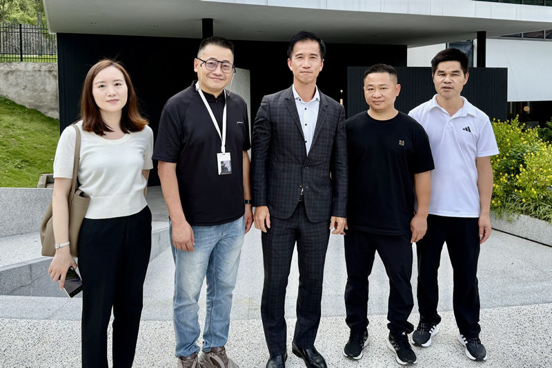 鄭震生(中)一行人在龍岩市新羅區外事辦主任、一級主任科員林良基 (右1)陪同下參觀該公司展示廳並與該公司體驗中心主任徐志山(左2)合照