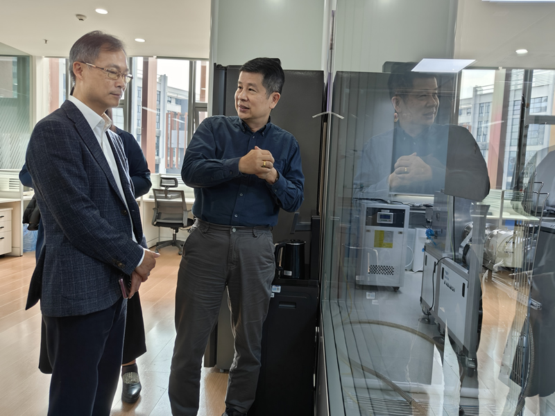 李炳威主任(左) 在半导体科技企业听取公司创始人介绍科技创新产品